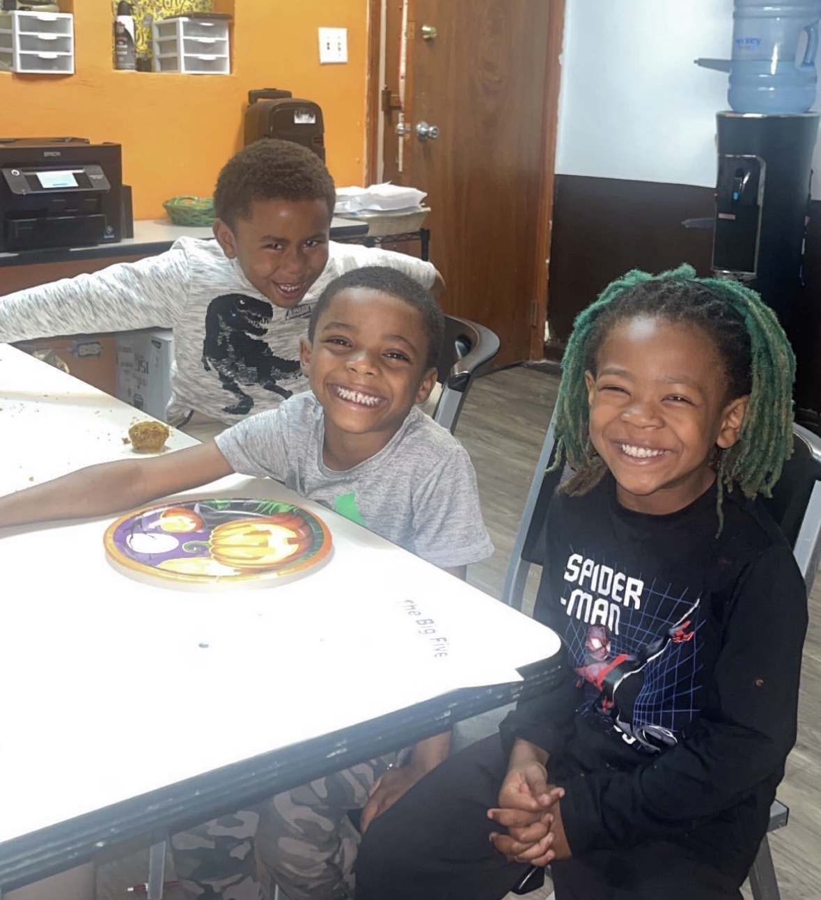 Three young boys laughing together at the youth center
