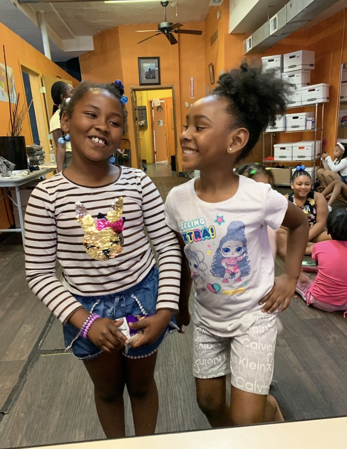 Two young girls smiling together at the youth center
